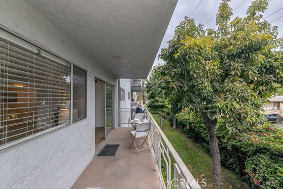 Balcony view of a residential area with trees and greenery.