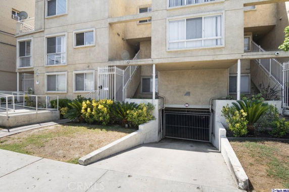 Front view of a multi-story residential building with a gated entrance to underground parking.