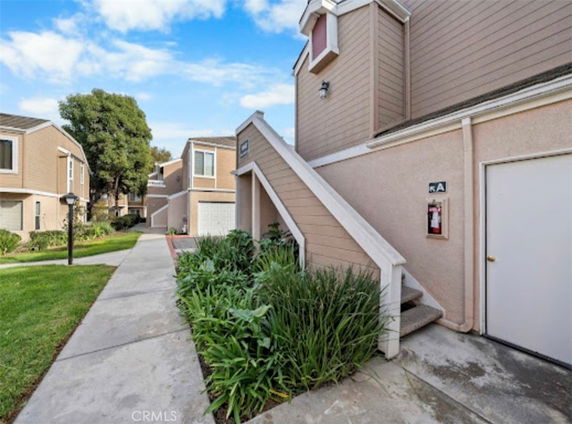 Front view of a multi-story residential building with external stairs and garage.