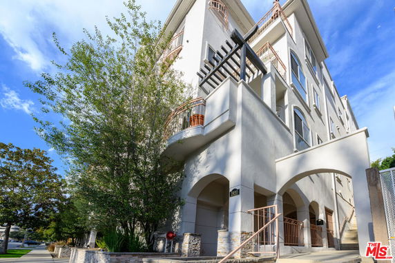 Front view of a multi-story building with arches and balconies.