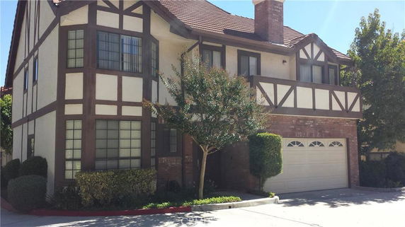 Front view of a two-story house with Tudor-style architecture and a double garage.