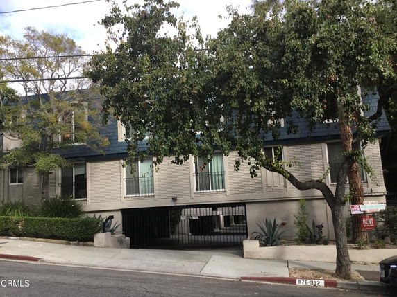 Front view of a multi-story building with a gated entrance.