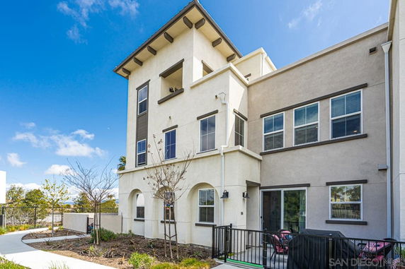 Front view of a multi-story house with balconies and large windows.
