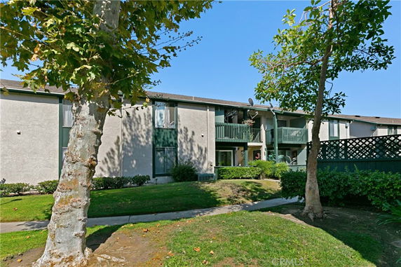 Front view of a two-story residential building with balconies and green trim.