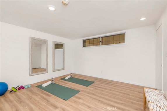 Indoor yoga and exercise room with mirrors and mats.