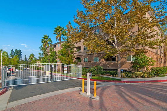 Front view of a multi-story residential building with a gated entrance.
