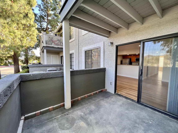 View of a balcony attached to a residential building with sliding glass doors.