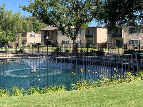 View of buildings with a pond and fountain in front.