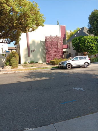 Front view of a building with a decorative facade and visible street.