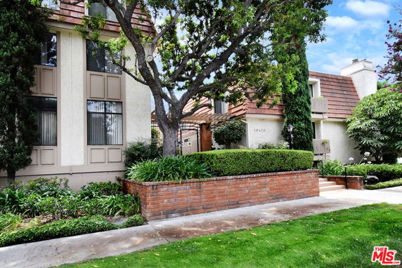 Front view of a house with a distinct roof and a landscaped garden.