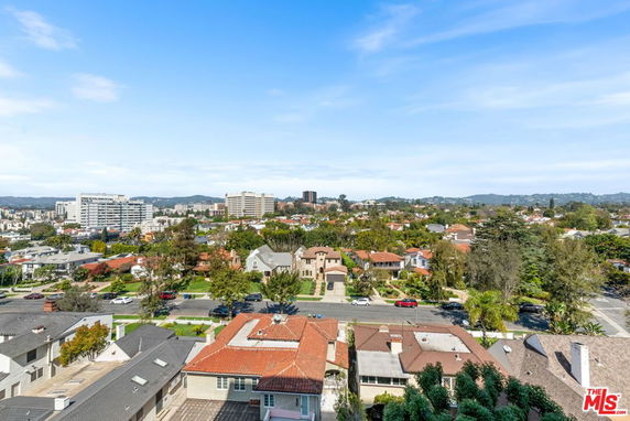 Wide panoramic view of a residential neighborhood with houses, trees, and distant buildings.
