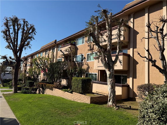 Front view of a multi-story apartment building with balconies.