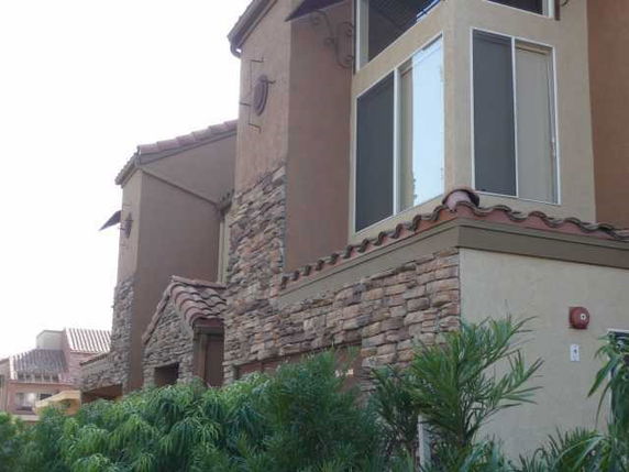 View of a multi-story house with stone and stucco exterior.