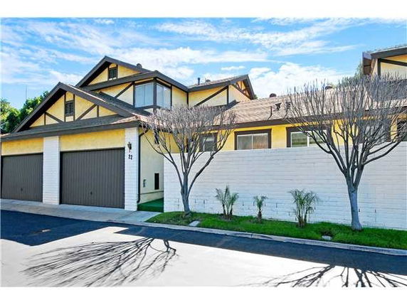 Front view of a two-story house with a double garage and yellow and brown exterior.