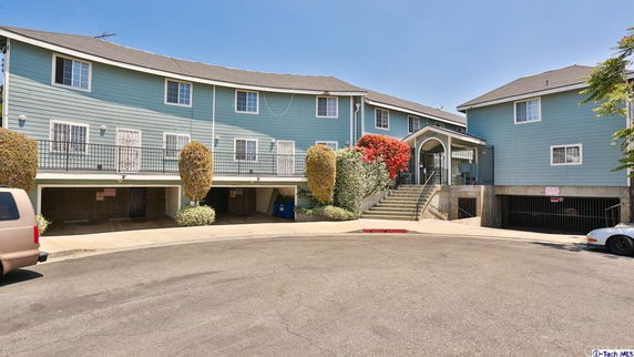 Front view of a multi-story residential building with covered parking.