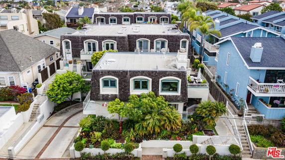 Front view of a multi-unit residential building with balconies and a rooftop terrace.