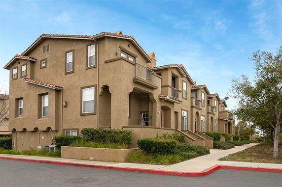 Front view of a multi-story residential building with balconies.