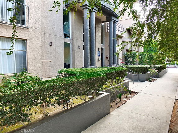 Front view of a multi-story building with columns and glass windows.