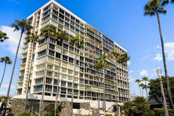 Front view of a multi-story apartment building with large windows and balconies.