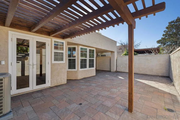 Front view of a house with a patio and pergola.