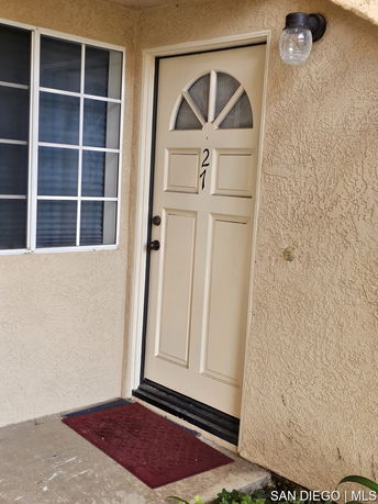 Front view of an entry door with a window and porch area.