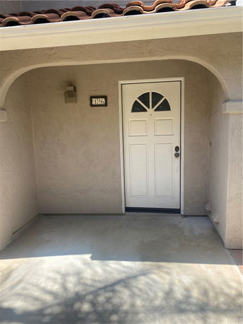 Front view of a house entrance with a white door and arched entryway.
