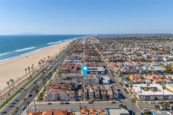 Aerial view of a coastal city with beachfront and residential buildings.