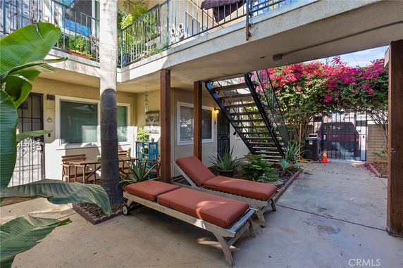 Outdoor lobby area with lounge chairs and staircase.
