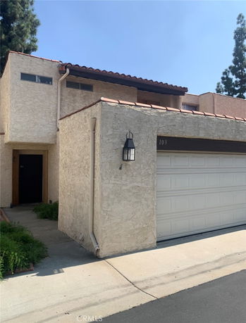 Front view of a two-story house with a tiled roof and attached garage.