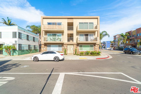 Front view of a three-story apartment building with balconies.