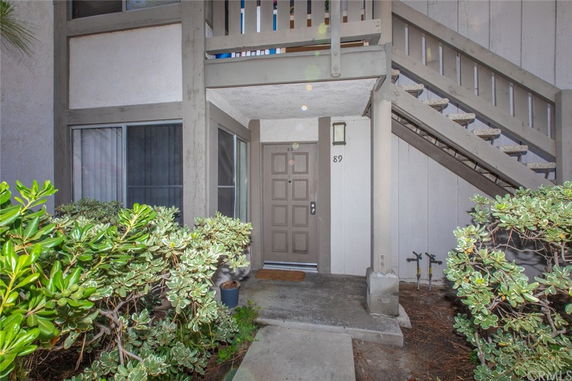 Entrance view of a residential unit with a staircase leading to an upper level.