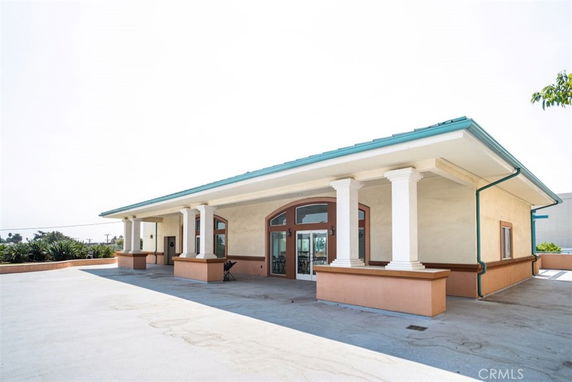 Front view of a single-story building with columns and large windows.