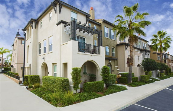 Front view of a multi-story residential building with a balcony.