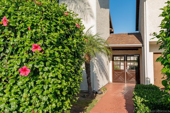 Front view of a building entrance with double doors and surrounding greenery.