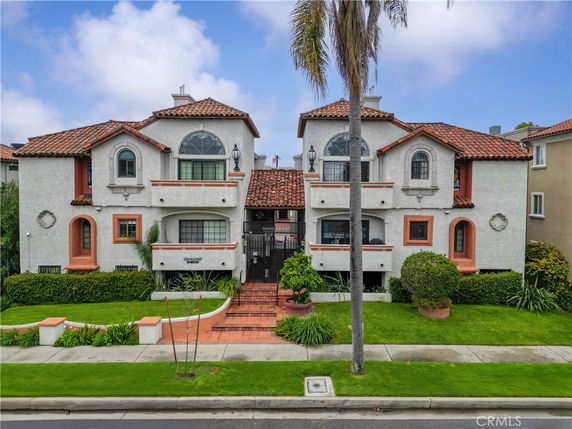Front view of a two-story house with decorative arches and a tiled roof.