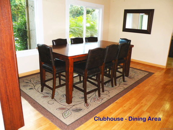 Dining area with a wooden table and chairs in a clubhouse.