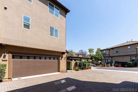 Outdoor parking area with a garage in a residential setting.