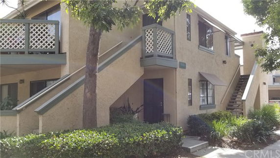 Front view of a two-story apartment building with exterior staircase.