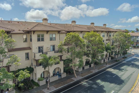Front view of a multi-story townhouse with arched entryways and balconies.