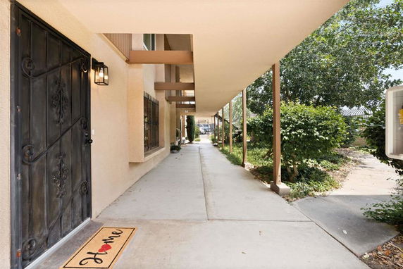 Front view of a house with a covered walkway and a decorative door.