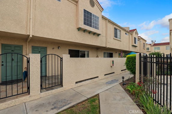 Front view of a two-story townhouse with gated entrances.