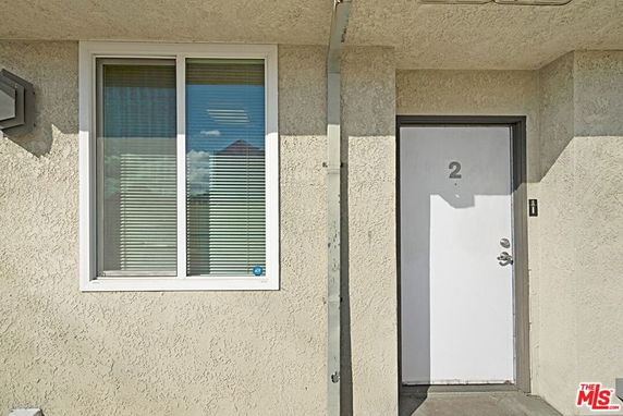 Front view of a building with a door labeled number 2 and a window.