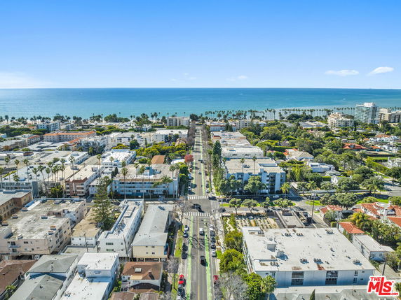 Panoramic view showing a residential area near the coastline with multiple buildings and the ocean in the background.