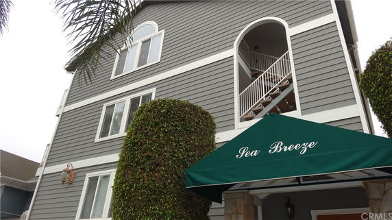 Front view of a multi-story building with a green awning labeled 'Sea Breeze'.