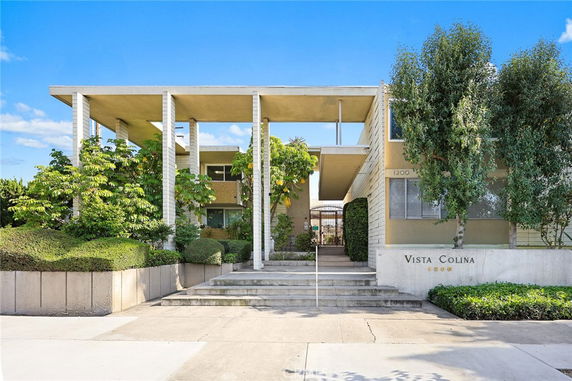 Front view of a modern multi-story building with a flat roof and prominent vertical columns.