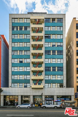 Front view of a multi-story commercial building with a modern facade and multiple balconies.