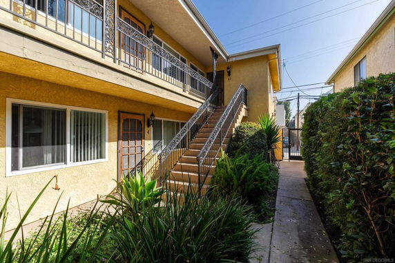 Front view of a two-story apartment building with an exterior staircase.