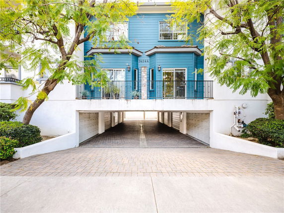 Front view of a two-story building with blue siding and a central garage entry.