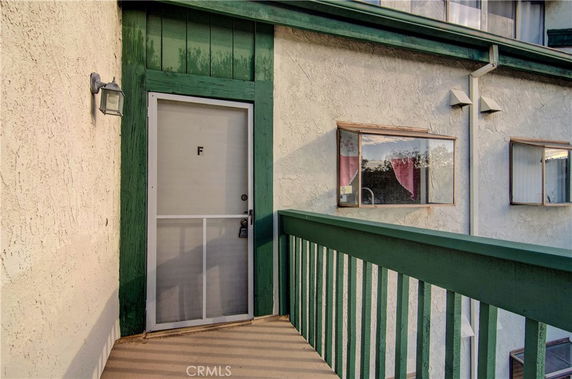 Front view of a building entrance with a green framed door and windows.