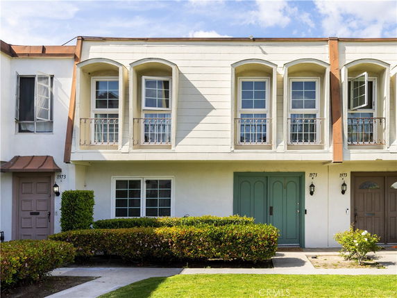 Front view of a two-story house with multiple windows and entry doors.